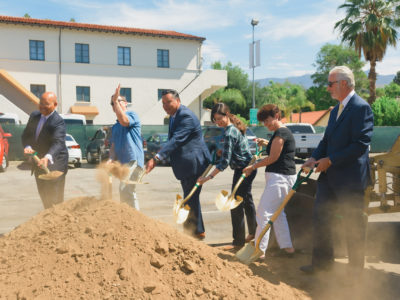 Photo of city officials, staff, and Playhouse Village Association Board Chair holding ceremonial gold shovels over a mount of dirt.