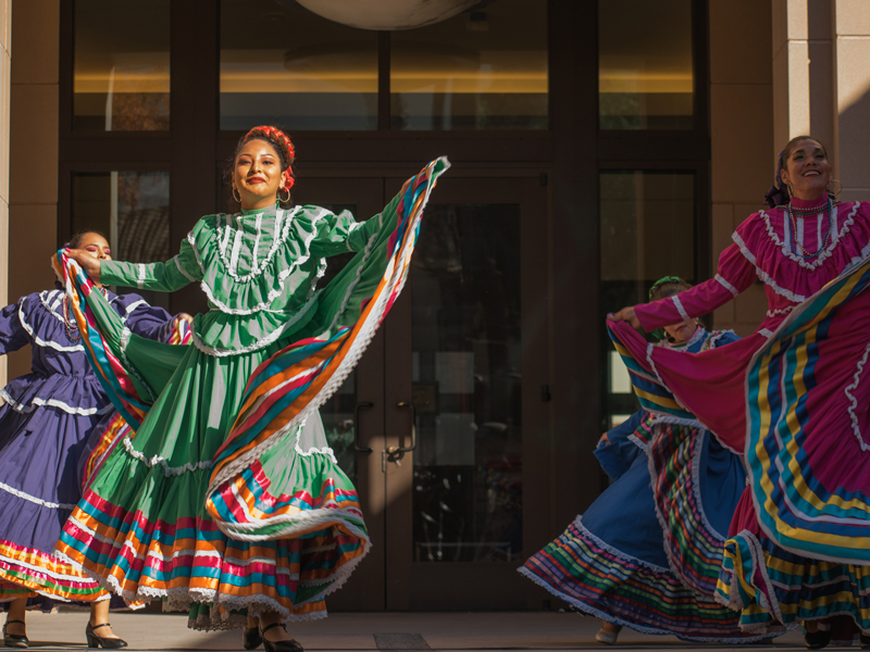 Photo of beautifully dressed women dancing Ballet Folklorico