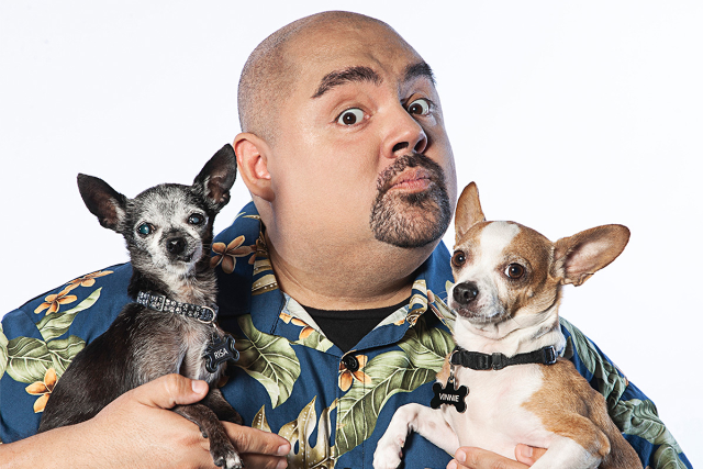 Photograph of comedian Gabriel Iglesias holding his two dogs.