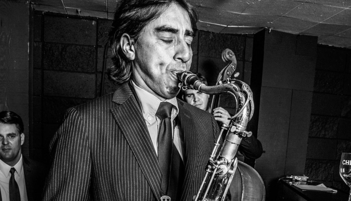 Musician Javier Vergara plays a saxophone in this black and white photo