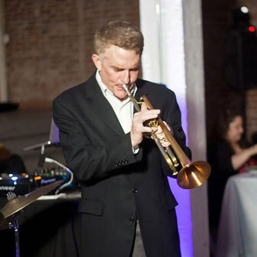 Jazz musician Elliott Caine plays the trumpet at a concert