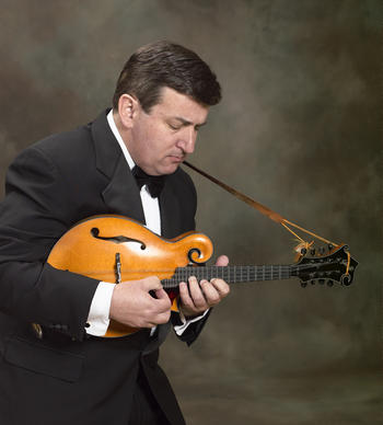 Evan Marshall plays mandolin against a black backdrop